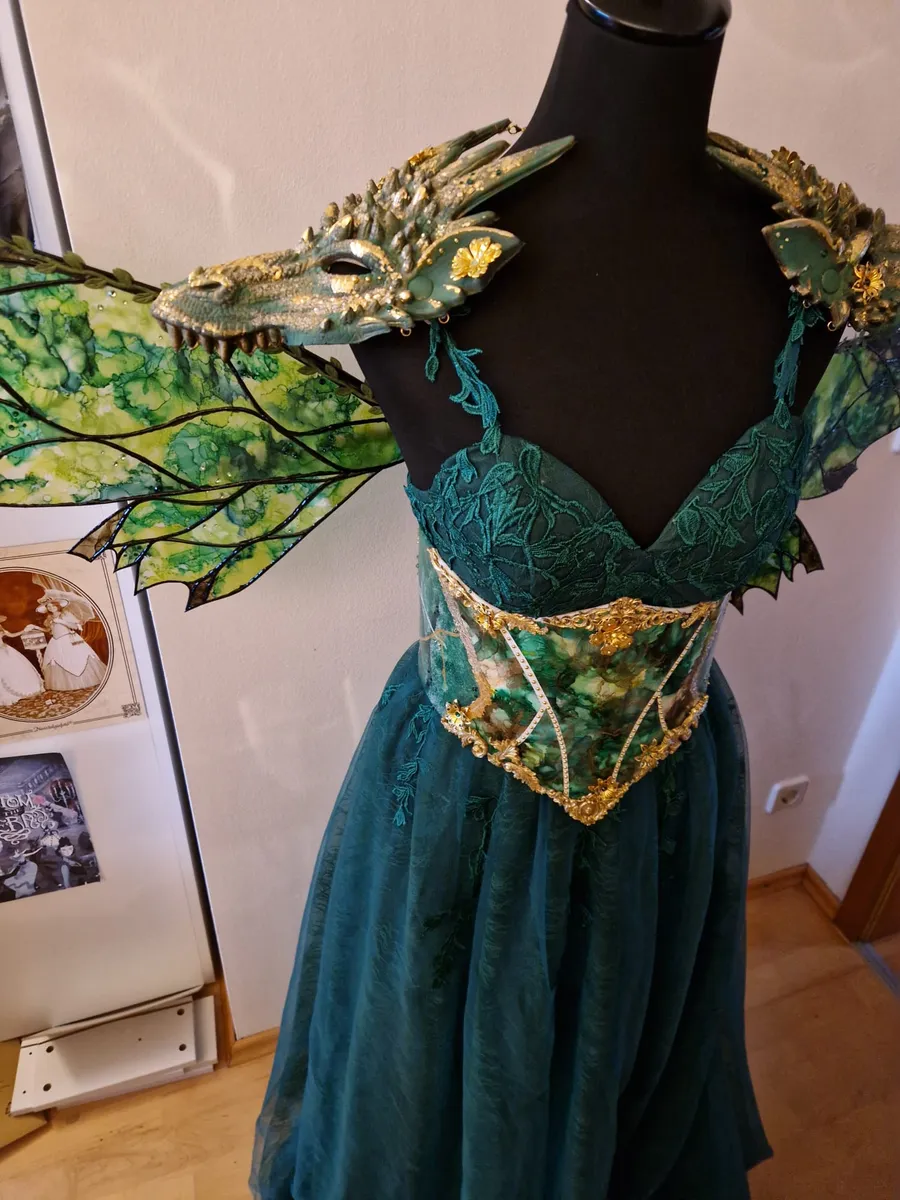 Grünes Drachenfeen-Kostüm mit Drachenkopf-Schulterteilen, marmorierten Flügeln und goldverziertem Korsett