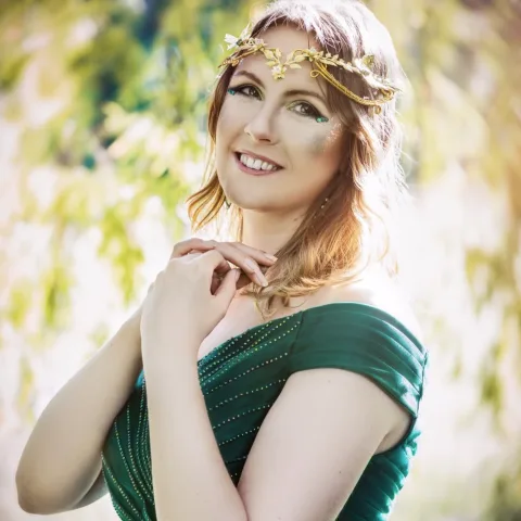 Nicole Bethkenhagen in einem grünen Kleid mit goldenem Kopfschmuck